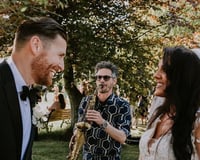 Saxophonist with bride and groom