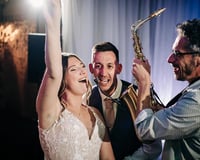 Saxophonist with bride and groom