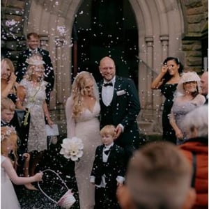 Bride and Groom walking through confetti after church wedding ceremony