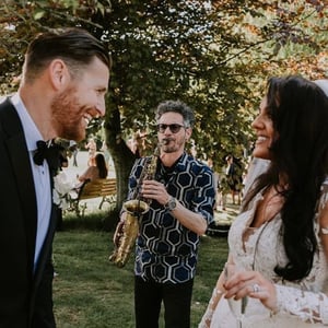 Saxophonist with bride and groom