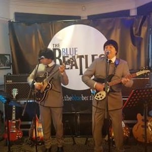 The Blue Beatles Duo performing in grey collarless suits