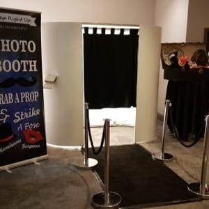 white photo booth with black carpet and ropes