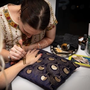 Henna being applied for a wedding guest
