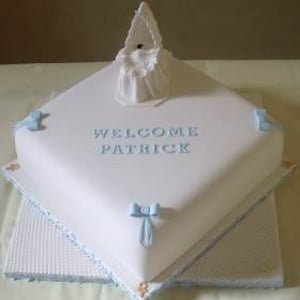 Exquisite boys Christening cake with an baby in a moses basket.
