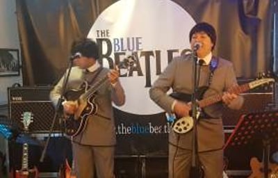 The Blue Beatles Duo performing in grey collarless suits