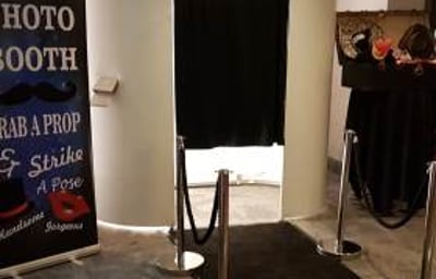 white photo booth with black carpet and ropes