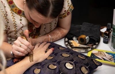 Henna being applied for a wedding guest