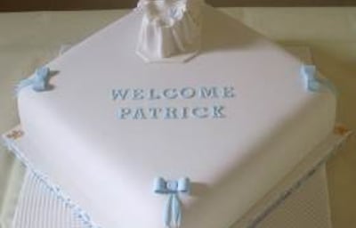 Exquisite boys Christening cake with an baby in a moses basket.