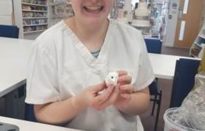 Young girl smiling during making her manikin at one of our Junior workshops.