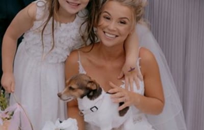 Bride posing with a surprise guest and her daughter
