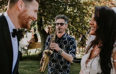Saxophonist with bride and groom