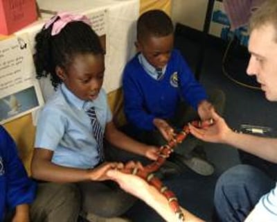 A very brave pupil holding Yazzoo the milk snake