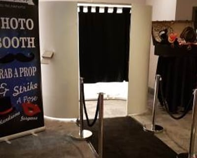 white photo booth with black carpet and ropes