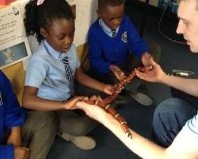 A very brave pupil holding Yazzoo the milk snake